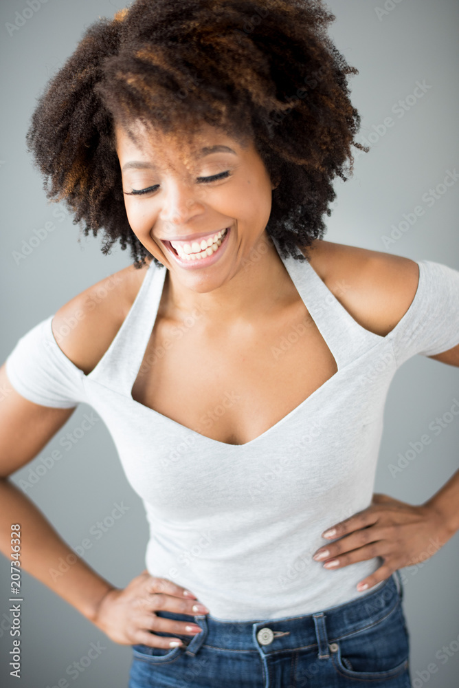 Smiling young woman standing against gray background Smiling young woman standing against gray background