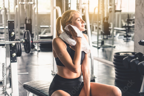 Beautiful women resting after finish workout set in gym.