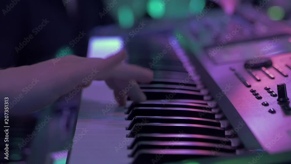 Hands playing synth on concert