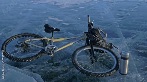 Man and his bicycle on ice. He looks at the beautiful ice in the cracks. First-person view. The cyclist is dressed in a gray down jacket, backpack and helmet. Ice of the frozen Lake Baikal. The tires