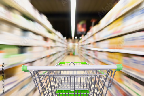 empty shopping cart with blur supermarket aisle with baby formula milk product on the shelf, motion blur photo