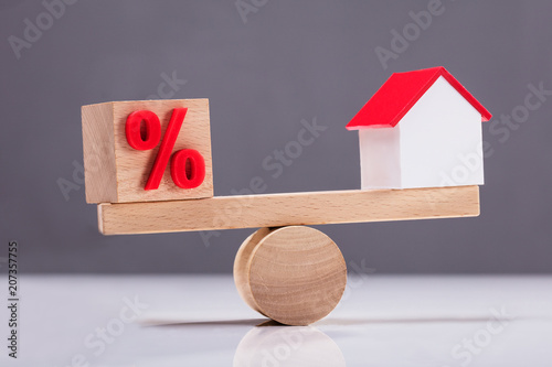 Seesaw Showing Balance Between Percentage Symbol And House Model