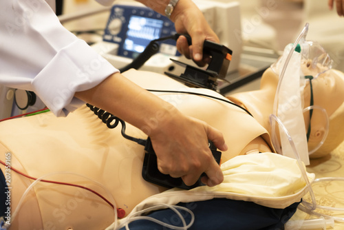 A white coat physician perform defibrillationon a doll during ACLS training program photo
