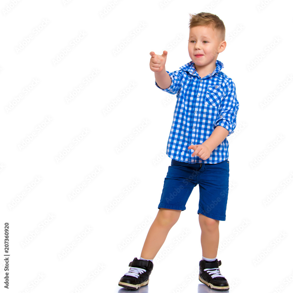 The boy points a finger at something. The boy points a finger at something.