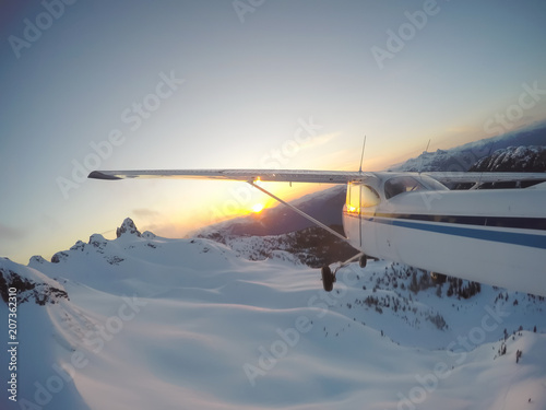 Airplane flying over the beautiful Canadian Landscape during a vibrant and colorful sunset. Taken near Vancouver, British Columbia, Canada.