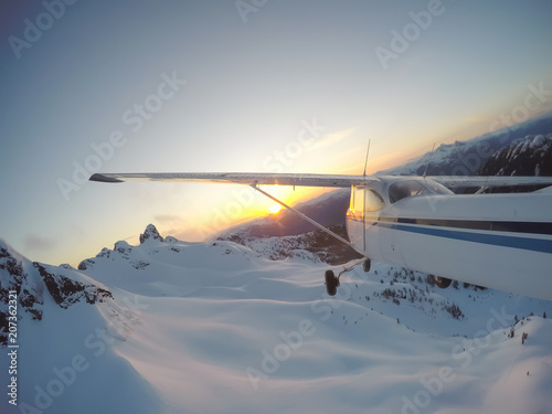 Airplane flying over the beautiful Canadian Landscape during a vibrant and colorful sunset. Taken near Vancouver, British Columbia, Canada.