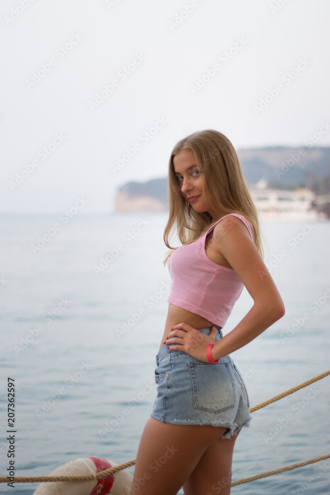 Portrait of young sexy blonde woman in short shorts by the sea Portrait of young sexy blonde woman in short shorts by the sea