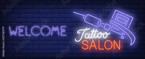 Welcome to tattoo salon neon sign. Professional tattoo machine and bright inscription on dark brick wall. Vector illustration in neon style for tattoo studio or luminous banner