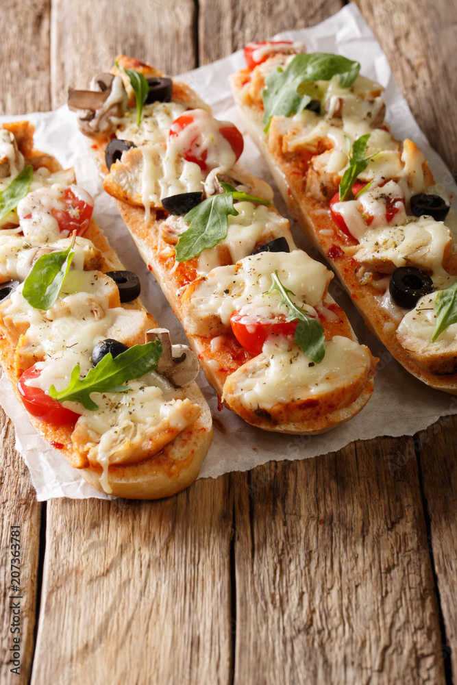 Delicious hot sandwich baguette baked with chicken, cheese, tomatoes, olives and mushrooms. vertical Delicious hot sandwich baguette baked with chicken, cheese, tomatoes, olives and mushrooms. vertical
