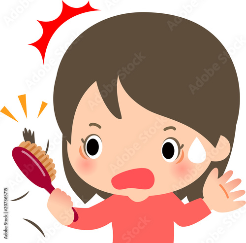 ヘアブラシに付いた抜け毛に驚く若い女性