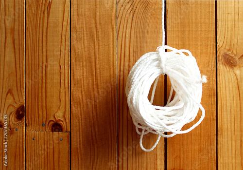 curled rope hanging on a wooden wall background