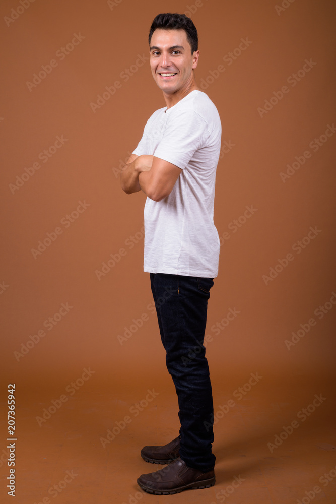 Young handsome Hispanic man against brown background Young handsome Hispanic man against brown background