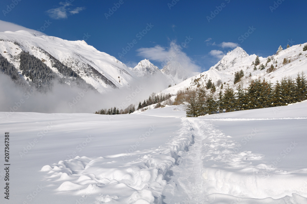 Track in the snow crossing a valley in the alpine mountain