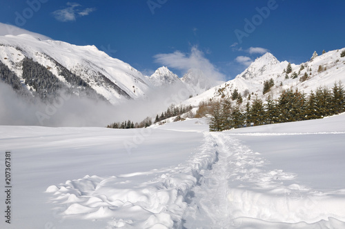 Track in the snow crossing a valley in the alpine mountain © coco