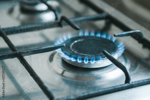 Gas. Kitchen stove with blue flames burning.