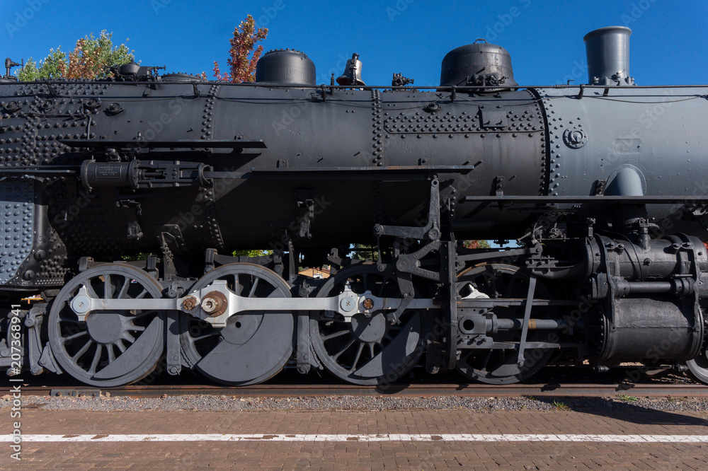 Old locomotive steam engine details. Detail of steam locomotive, side view, wheels, rods, part of the boiler Old locomotive steam engine details. Detail of steam locomotive, side view, wheels, rods, part of the boiler