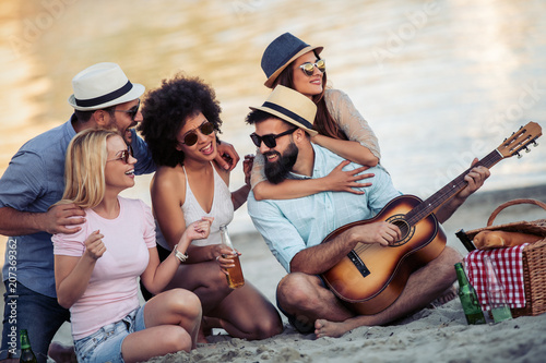 Group of friends with guitar having fun on the beach © ivanko80