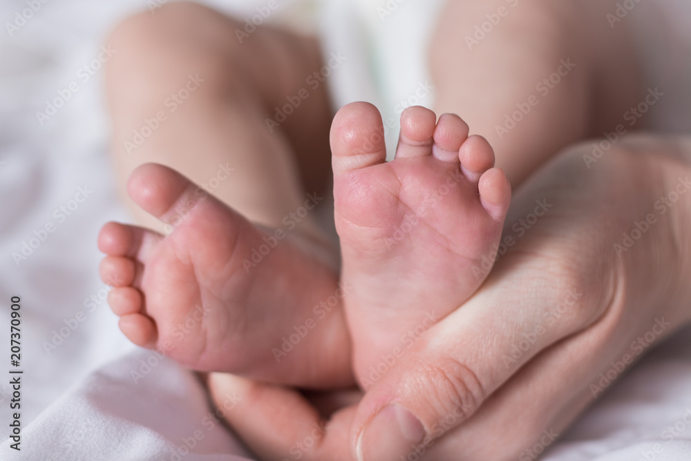 Beautiful image of the feet of a newborn baby in female hands Beautiful image of the feet of a newborn baby in female hands