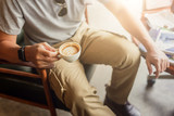 Guy wearing cargo pants and drinking a coffee in coffee shop