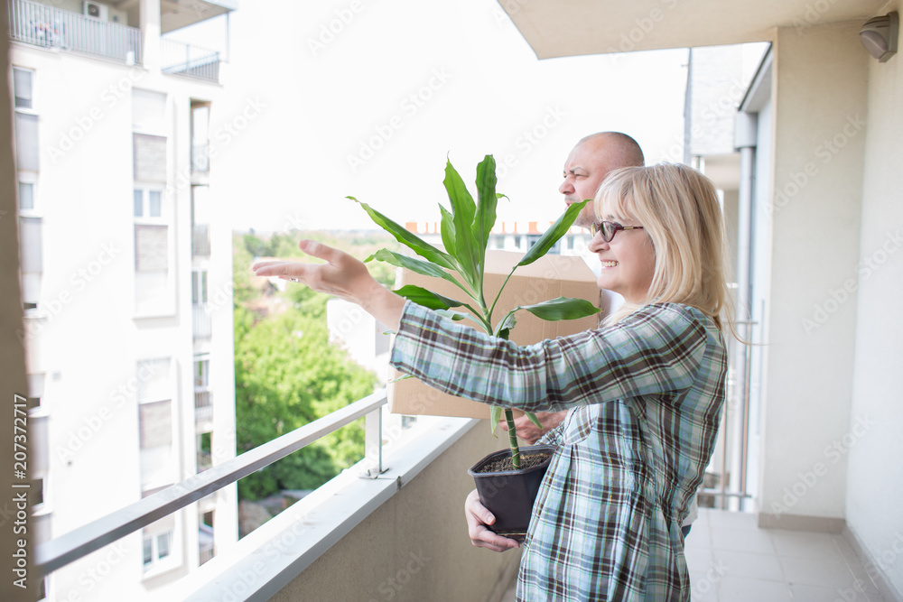 Middle aged couple enjoying view from new apartment Middle aged couple enjoying view from new apartment