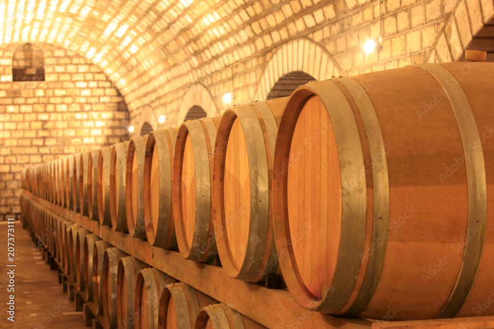 Wine barrels stacked in the cellar of the winery Wine barrels stacked in the cellar of the winery