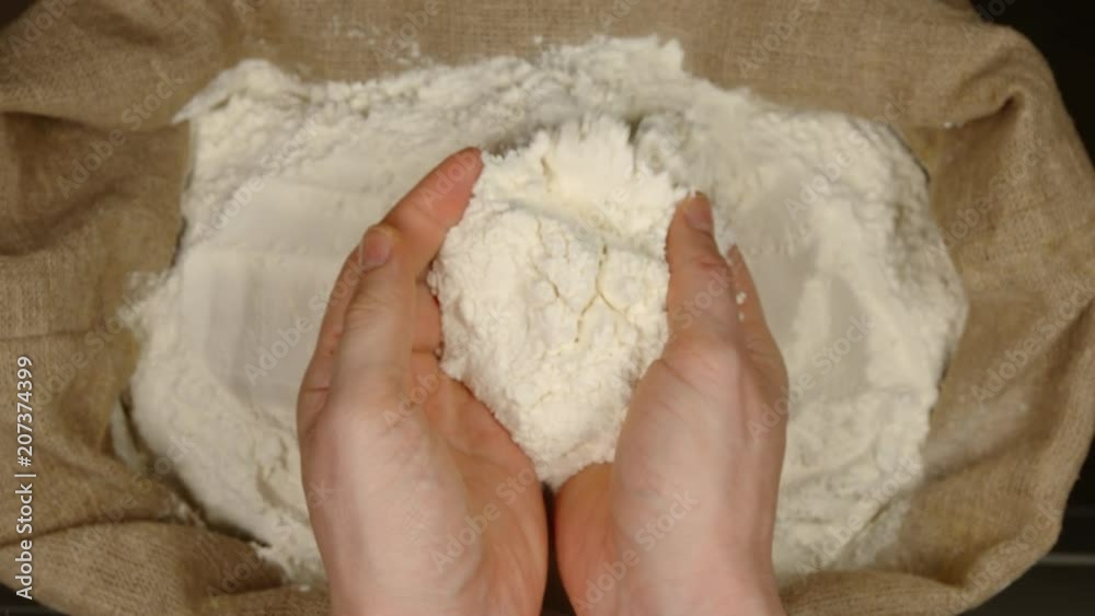 TOP VIEW: Human takes of a wheat powder by a hands from a sac TOP VIEW: Human takes of a wheat powder by a hands from a sac