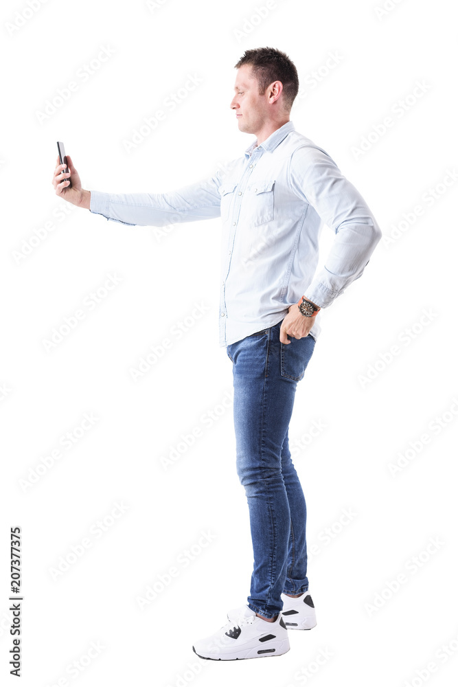 Profile view of elegant handsome business man taking photo with cellphone with hand on hip. Full body isolated on white background. Profile view of elegant handsome business man taking photo with cellphone with hand on hip. Full body isolated on white background.