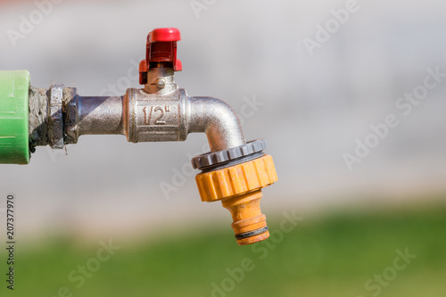 closed water faucet or tap in blur garden background photo