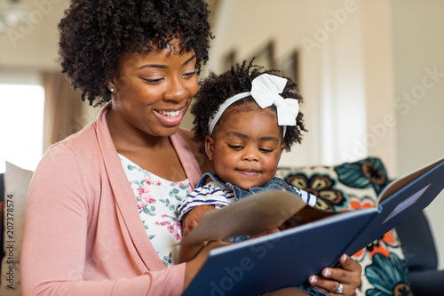 Mother reading a book to her little girl.