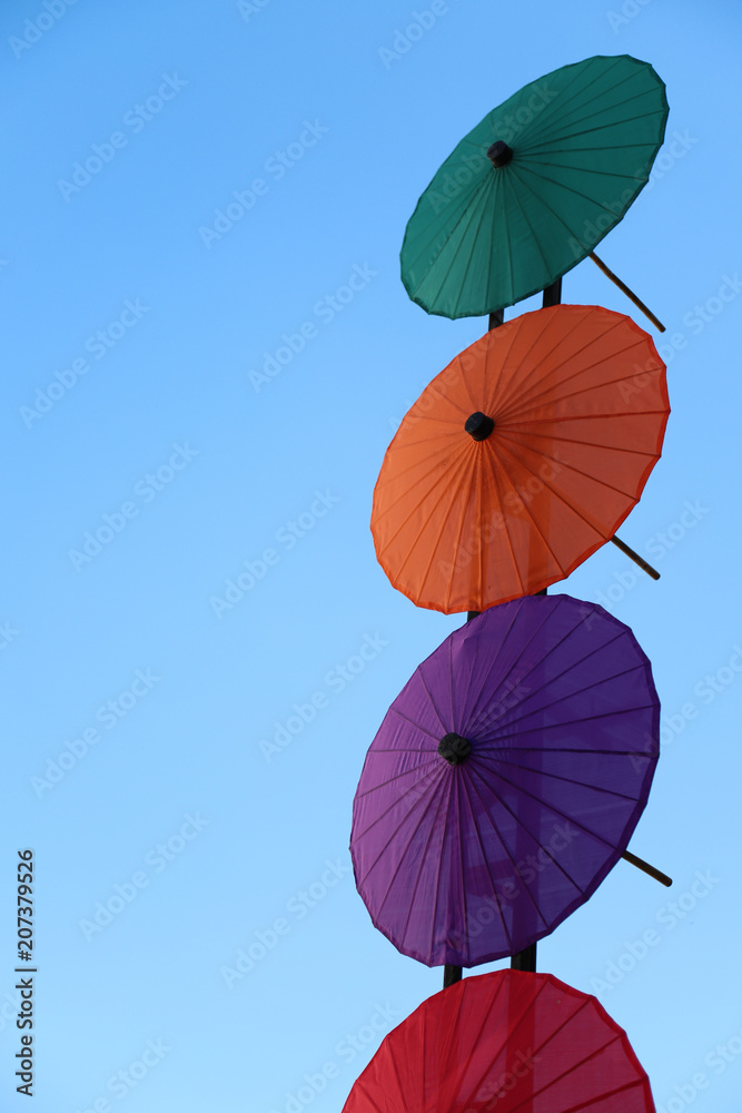 Two couples of colorful umbrellas with blue sky in sunny day.