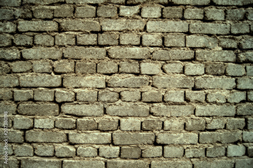 background of a gray, old brick wall, built on clay