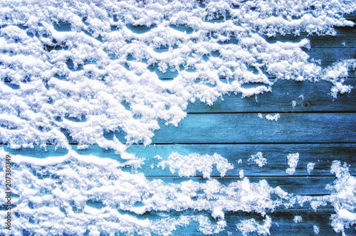 Blue wooden background in white snow