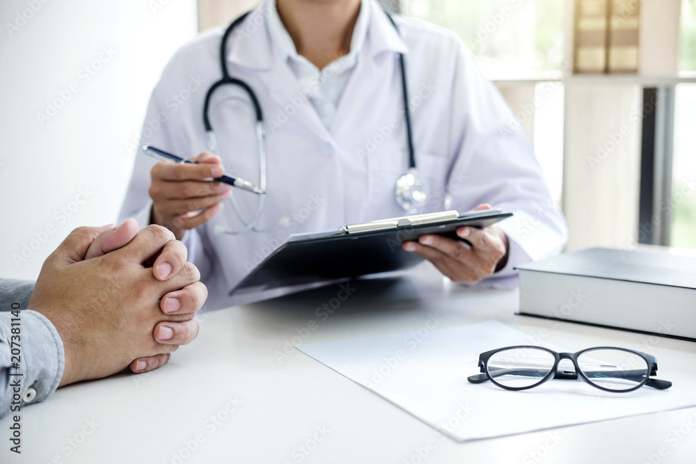 Doctor filling up an history form while consulting to patient and recommend treatment methods and how to rehabilitate