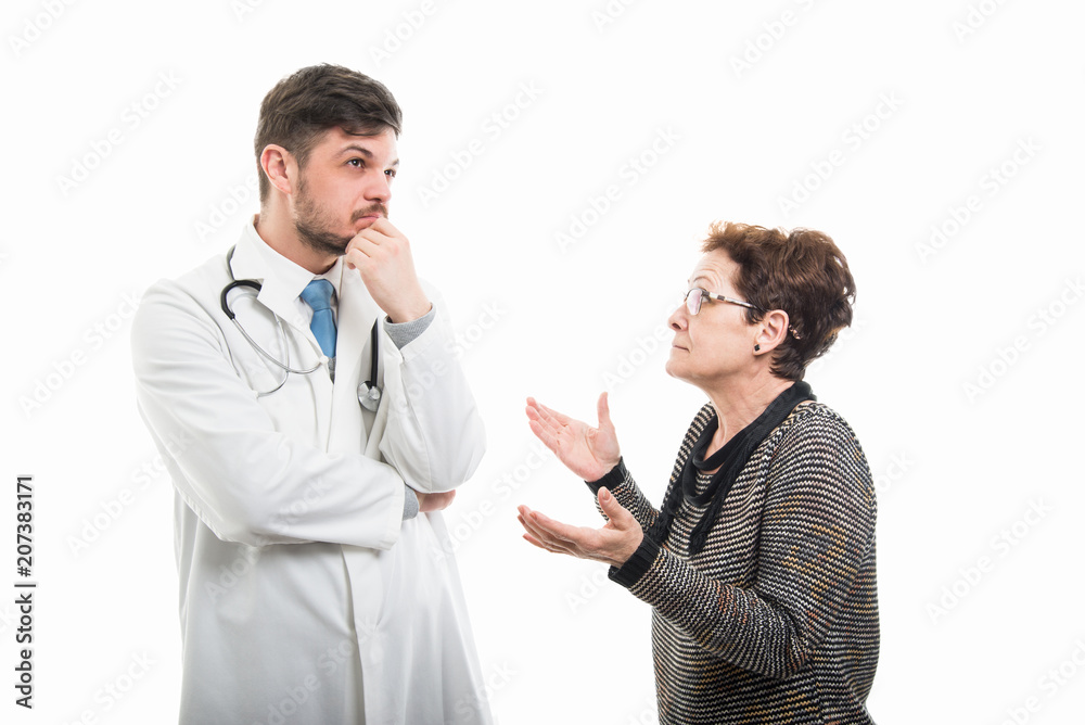 Female senior patient explaining something to male doctor Female senior patient explaining something to male doctor
