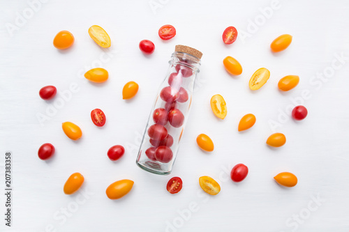 Red and yellow cherry tomatoes on a white background