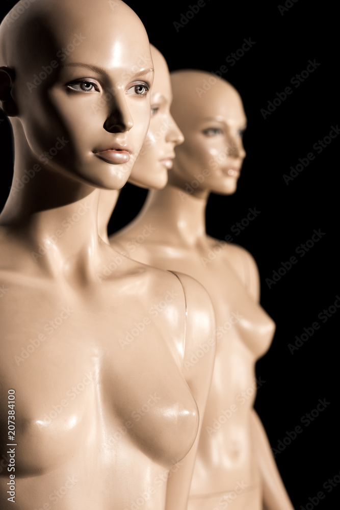 close-up view of naked bald mannequins on black, selective focus