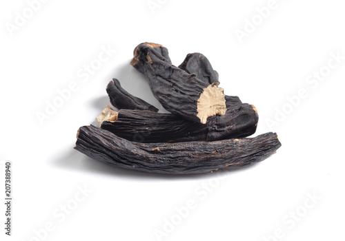 Dried medicinal herbs raw materials isolated on white. Root of Symphytum.