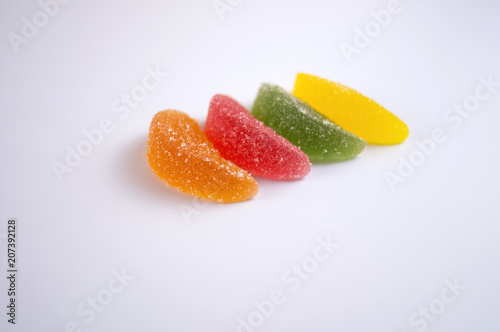 Isolated pictures of pieces of colored marmalade on a light background