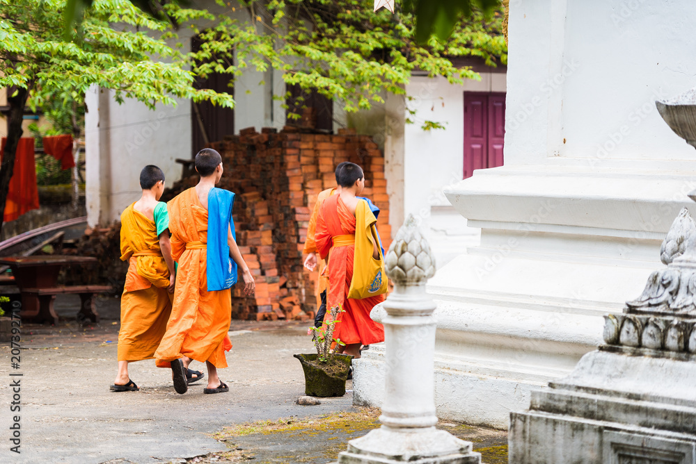 LOUANGPHABANG, LAOS - JANUARY 11, 2017: Group of monks on a city street. Copy space for text.