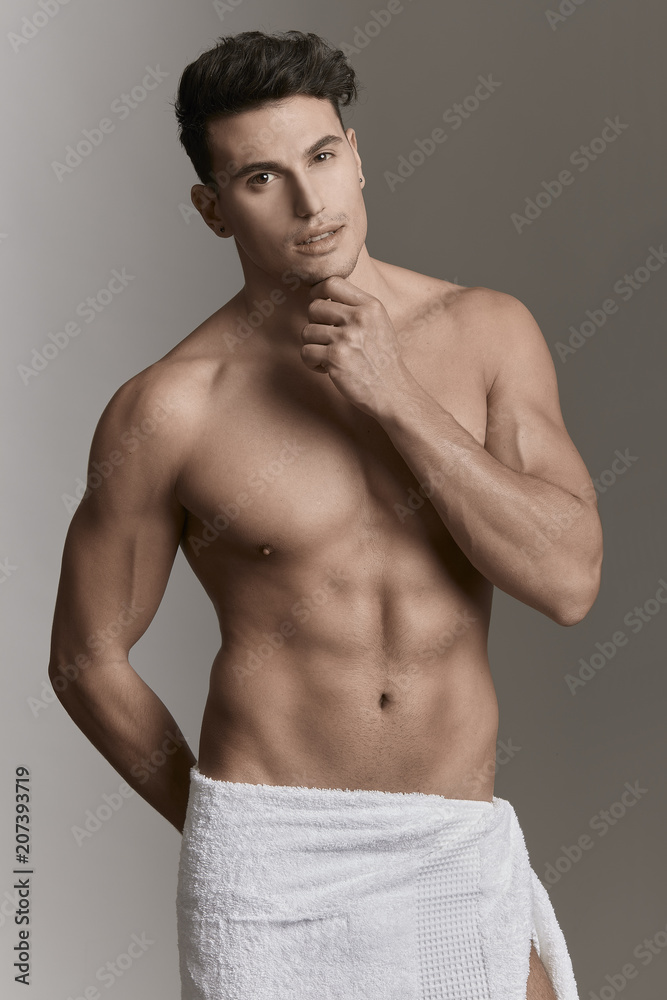 MAN WEARING A WHITE TOWEL WITH HAND ON HIS FACE