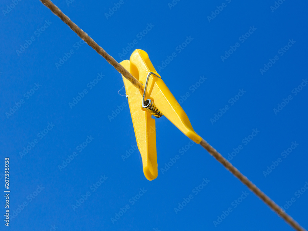 Clothespins on a clothesline against a blue sky Clothespins on a clothesline against a blue sky
