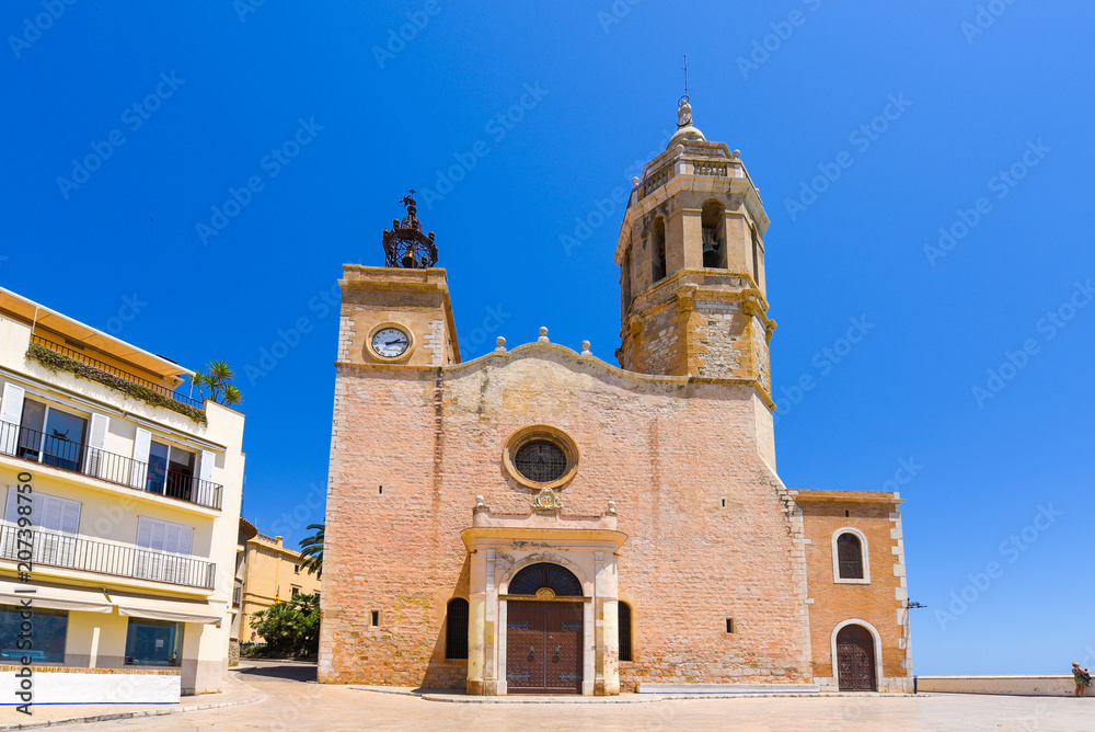 Fototapeta premium SITGES, CATALUNYA, SPAIN - JUNE 20, 2017: View of the church of of Sant Bartomeu and Santa Tecla. Copy space for text.
