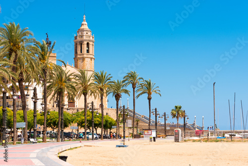 SITGES, CATALUNYA, SPAIN - JUNE 20, 2017: View of the embankment and ñhurch of Sant Bartomeu and Santa Tecla. Copy space for text. Isolated on blue background.