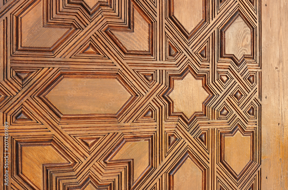 Old Arabic wooden door carved with Islamic style in the Alhambra Palace of Granada, Andalusia, Spain Old Arabic wooden door carved with Islamic style in the Alhambra Palace of Granada, Andalusia, Spain