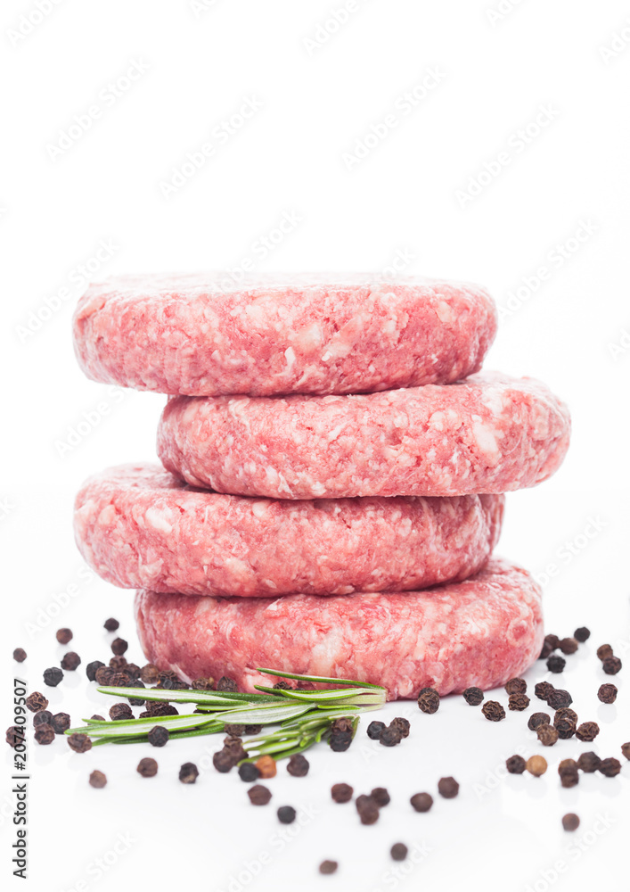 Raw fresh beef burgers with pepper and rosemarine Raw fresh beef burgers with pepper and rosemarine