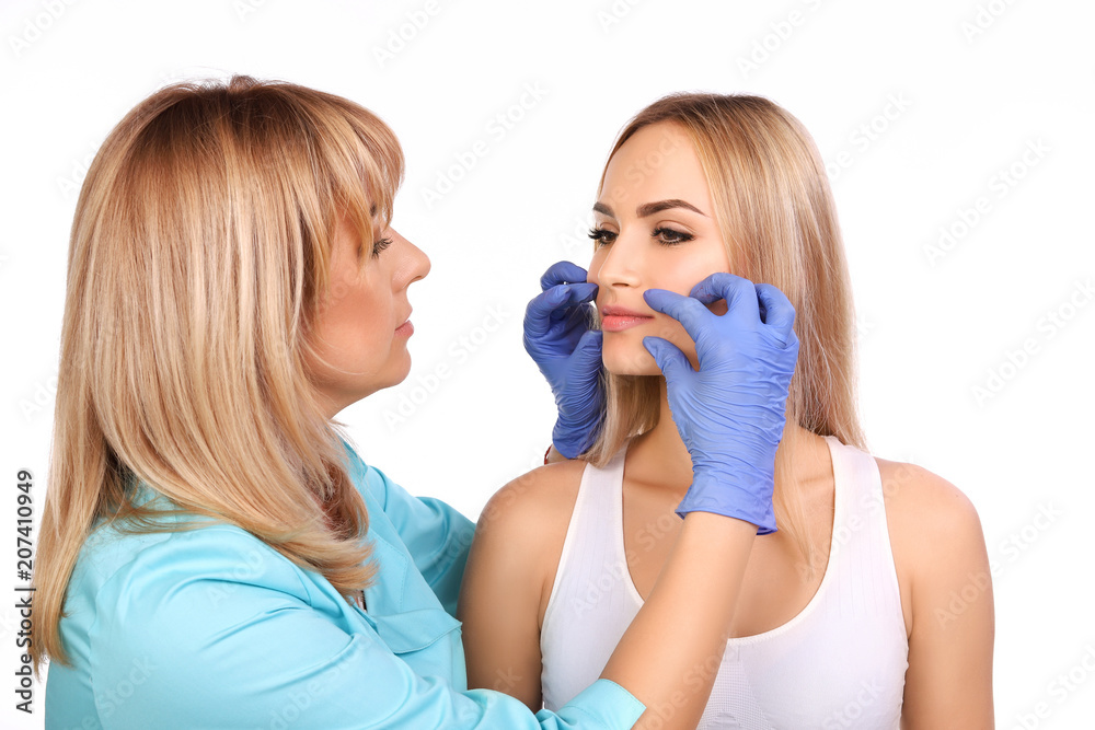 Cosmetologist making permanent makeup on woman's lips Cosmetologist making permanent makeup on woman's lips