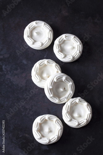 Six meringues on dark ground