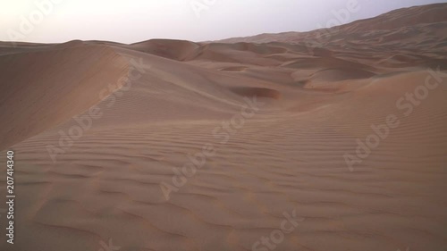 Wind chases the sand over beautiful dunes in the Rub al Khali desert before sunset United Arab Emirates stock footage video