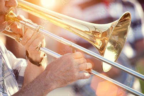 young man playing trombone on street photo