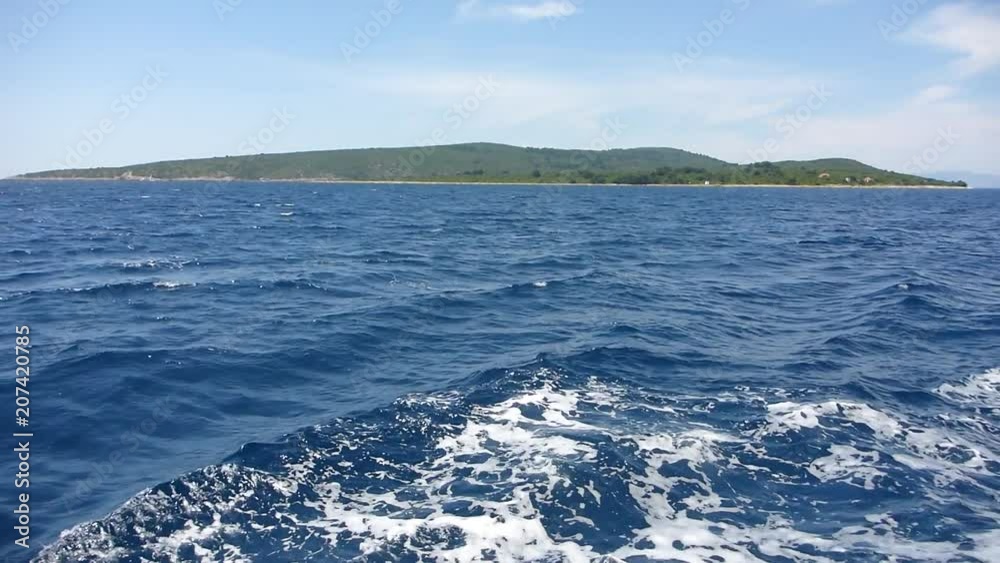 Waves pass over the sea with mountains of Croatia in the distance Waves pass over the sea with mountains of Croatia in the distance